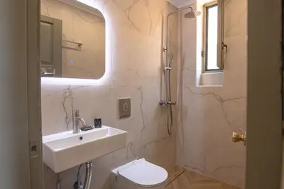 a bathroom with a sink and a toilet and a mirror at Delfini Apartments in Kissamos