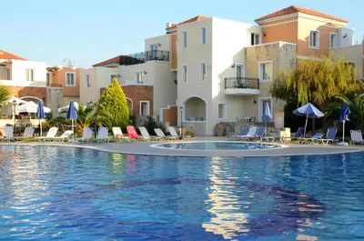 a swimming pool in a resort with chairs and umbrellas at Chrispy Waterpark Resort - All inclusive in Kolymvari
