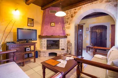 a living room with a tv and a fireplace at Samonas Traditional Villas in Samonás