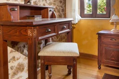 a wooden desk with a chair next to a table at Samonas Traditional Villas in Samonás