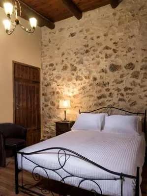 a bedroom with a bed and a stone wall at Villa Malaxa Private Luxury with Amazing View in Maláxa