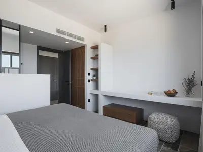 a bedroom with a bed and a table and a chair at Brand new Villa Eleftheria BY APOKORONAS-VILLAS in Plaka