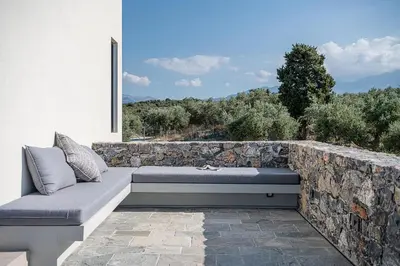 a stone wall with a bench on a patio at Brand new Villa Eleftheria BY APOKORONAS-VILLAS in Plaka