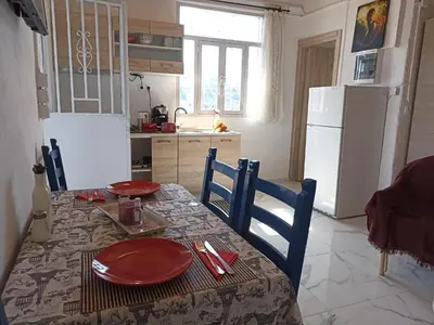 a kitchen with a table with red plates on it at Chania Mini Villas in Skinés