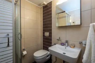 a bathroom with a sink and a toilet and a mirror at Aris Boutique Hotel in Palaiochóra