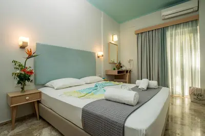 a bedroom with a large bed with towels on it at Aris Boutique Hotel in Palaiochóra