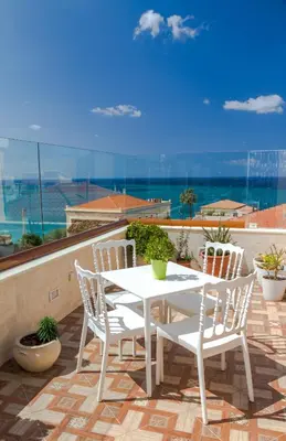 a white table and chairs on a balcony with a view at Halepa Hotel in Chania Town