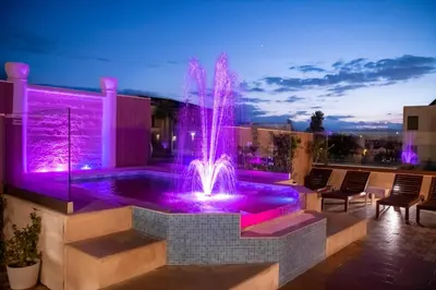 a fountain in the middle of a patio with purple lights at Halepa Hotel in Chania Town