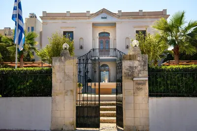 a white house with a gate and a flag at Halepa Hotel in Chania Town