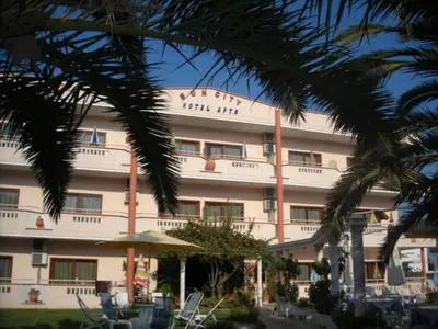 a building with a palm tree in front of it at Sun City in Kato Daratso