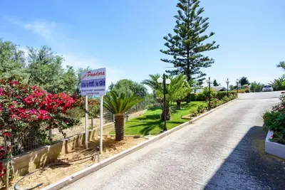 a street with trees and a sign on the side of a road at PanDora maisonette with beautiful gardens and pool in Maleme