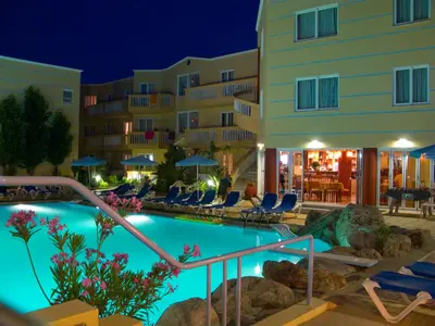 a hotel with a swimming pool at night at Futura Hotel in Maleme