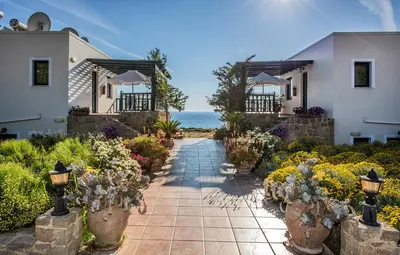 a walkway in front of a house with flowers at Magnolia Apartments and Studios in Falasarna