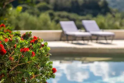 a group of chairs sitting next to a body of water at Villa Lucy by PosarelliVillas in Plataniás