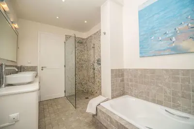 a bathroom with a tub and a sink and a shower at Villa Lucy by PosarelliVillas in Plataniás