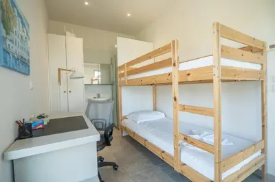 a bedroom with two bunk beds and a desk at Villa Lucy by PosarelliVillas in Plataniás