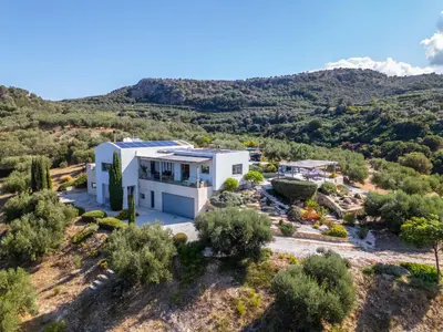 an aerial view of a white house with a mountain in the background at Villa Lucy by PosarelliVillas in Plataniás
