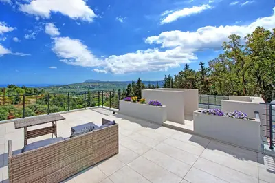 a patio with a table and chairs and a view at Villa Kallos by PosarelliVillas in Païdhokhórion