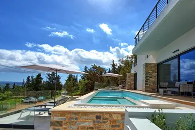 a house with a swimming pool and a patio at Villa Kallos by PosarelliVillas in Païdhokhórion
