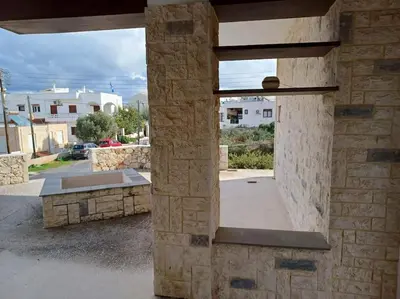 a stone wall with a view of a parking lot at Mini Villa Kalathas in Kalathas