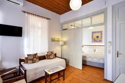 a bedroom with a bed and a couch and a tv at Silde Studios & Apartments in Chania Town