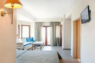 a hotel room with a bed and a couch at Frideriki Studios & Apartments in Plataniás