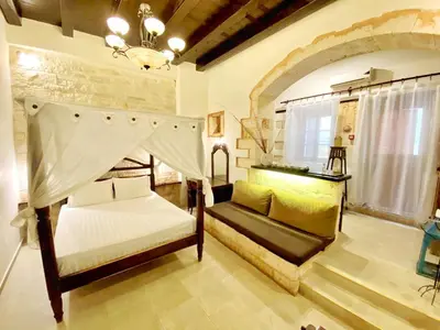 a bedroom with two beds and a chandelier at Boutique Hotel Del Doge in Chania Town