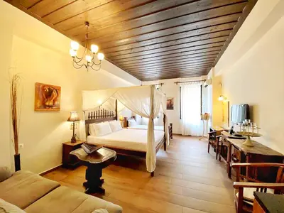 a bedroom with a bed and a couch and a table at Boutique Hotel Del Doge in Chania Town