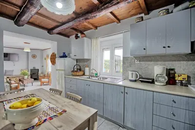 a kitchen with a table with a bowl of fruit on it at Aretousa by PosarelliVillas in Dhrakóna