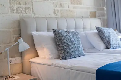 a white bed with white pillows and a lamp at Falasarna Luxury Villas I Private 