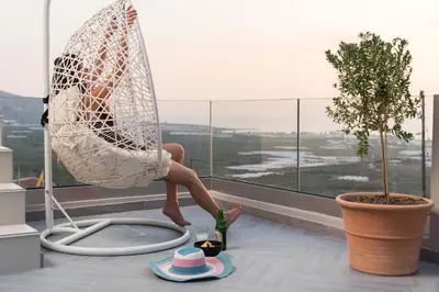 a woman sitting in a hammock on top of a window at Falasarna Luxury Villas I Private 