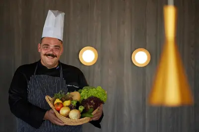 a man in a chef hat holding a basket of vegetables at Asterion Suites & Spa - Designed for Adults in Gerani Chanion