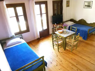 a room with two beds and a table with a tableablish at Madonna Studios in Chania Town