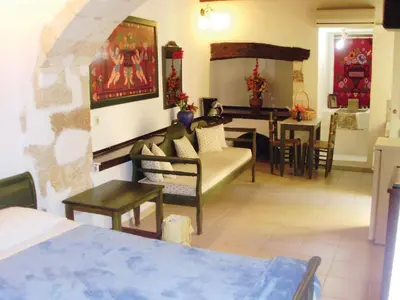 a living room with a couch and a dining room at Madonna Studios in Chania Town