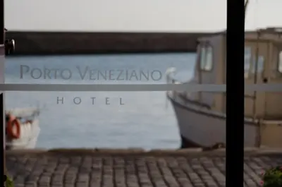 a sign for a hotel in front of a boat at Porto Veneziano Hotel in Chania Town
