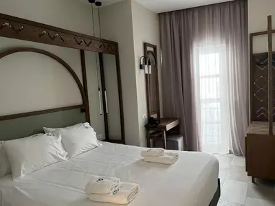 a hotel room with a bed with two towels on it at El Greco Hotel in Chania Town