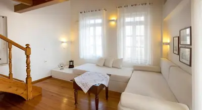 a white living room with a white couch and windows at Ontas Traditional Hotel in Chania Town
