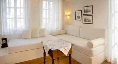 a white living room with a couch and a table at Ontas Traditional Hotel in Chania Town