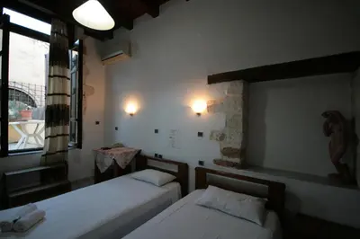 a bedroom with two beds and a window at Chania Rooms in Chania Town