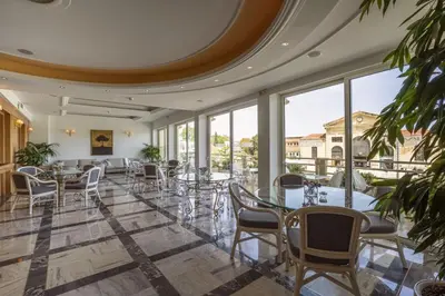 a dining room with tables and chairs and windows at Kydon The Heart City Hotel in Chania Town