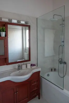 a bathroom with a sink and a shower and a tub at Villa Meltemi in Daratso