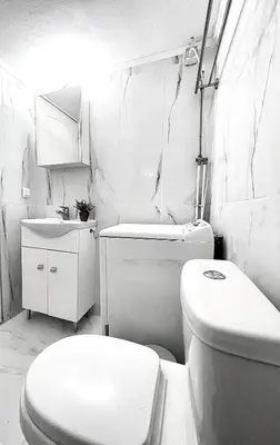 a white bathroom with a toilet and a sink at Odyseia Apts I at the center of the City & Old Town in Chania Town