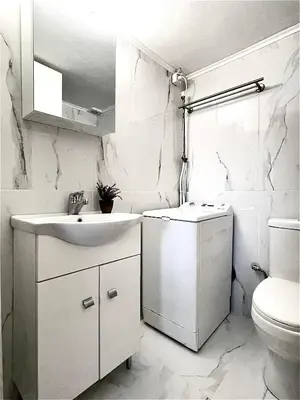 a white bathroom with a sink and a toilet at Odyseia Apts I at the center of the City & Old Town in Chania Town