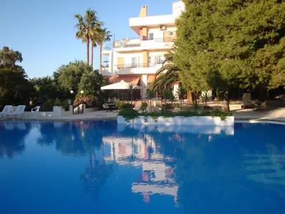 a swimming pool in front of a large building at Monte Vardia in Chania Town