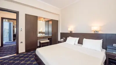 a hotel room with a large bed and a bathroom at Monte Vardia in Chania Town