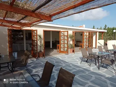 a patio at a hotel with tables and chairs at Alexandros Studios in Kalamaki Chanion