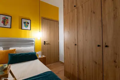a bedroom with a bed and a yellow wall at Alsalos Sea View Apartment in Chania Town