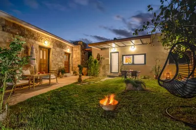 a backyard with a fire pit in the grass at Cavos Luxury Apartments in Kissamos