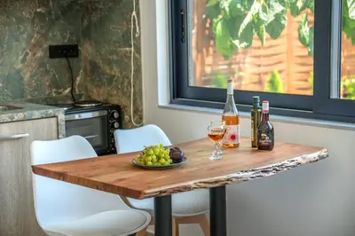 a table with wine bottles and a bowl of grapes at Cavos Luxury Apartments in Kissamos