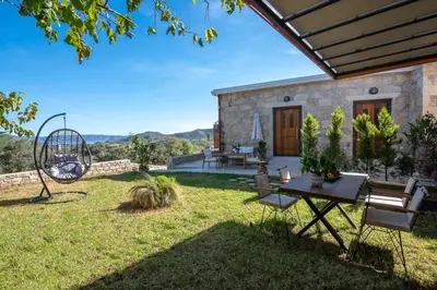 a patio with a table and chairs in a yard at Cavos Luxury Apartments in Kissamos